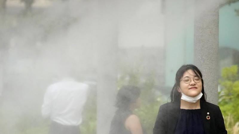 Orang-orang yang memegang payung duduk di bangku di bawah terik matahari di sebuah taman di Tokyo, Senin, 8 Juli 2024. Cuaca panas pada hari Senin telah terjadi dengan suhu meningkat lebih dari 35 derajat Celcius (95 derajat Fahrenheit) di Tokyo, menurut Jepang Badan Meteorologi. (AP Photo/Eugene Hoshiko)