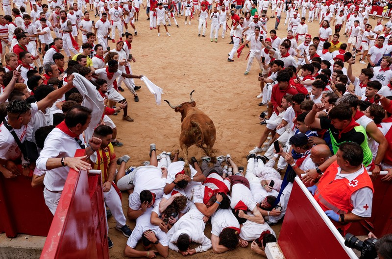 Orang-orang yang bersuka ria bersiap saat seekor sapi liar melompati mereka, di festival San Fermin di Pamplona, Spanyol, 8 Juli 2024. Orang-orang yang bersuka ria bersiap saat seekor sapi liar melompati mereka, di festival San Fermin di Pamplona, Spanyol, 8 Juli 2024. (REUTERS/Susana Vera)