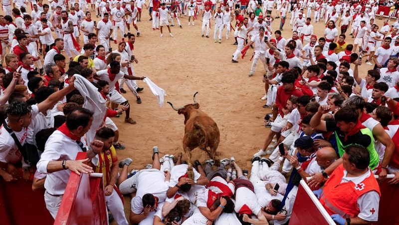 Orang-orang yang bersuka ria bersiap saat seekor sapi liar melompati mereka, di festival San Fermin di Pamplona, ​​Spanyol, 8 Juli 2024. (REUTERS/Susana Vera)