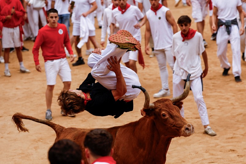 Orang-orang yang bersuka ria bersiap saat seekor sapi liar melompati mereka, di festival San Fermin di Pamplona, Spanyol, 8 Juli 2024. Orang-orang yang bersuka ria bersiap saat seekor sapi liar melompati mereka, di festival San Fermin di Pamplona, Spanyol, 8 Juli 2024. (REUTERS/Susana Vera)