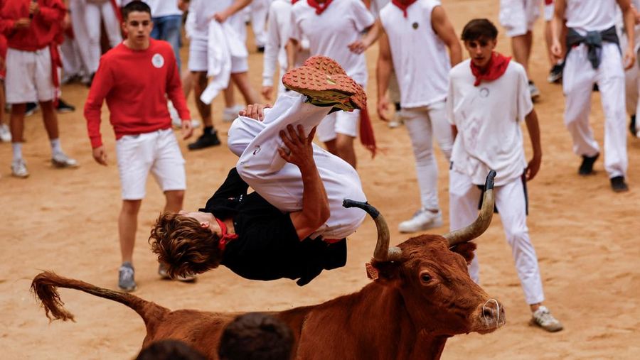 Orang-orang yang bersuka ria bersiap saat seekor sapi liar melompati mereka, di festival San Fermin di Pamplona, ​​Spanyol, 8 Juli 2024. (REUTERS/Susana Vera)