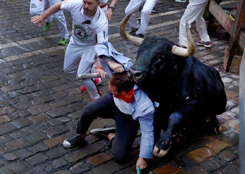 Orang-orang yang bersuka ria bersiap saat seekor sapi liar melompati mereka, di festival San Fermin di Pamplona, ​​Spanyol, 8 Juli 2024. (REUTERS/Susana Vera)