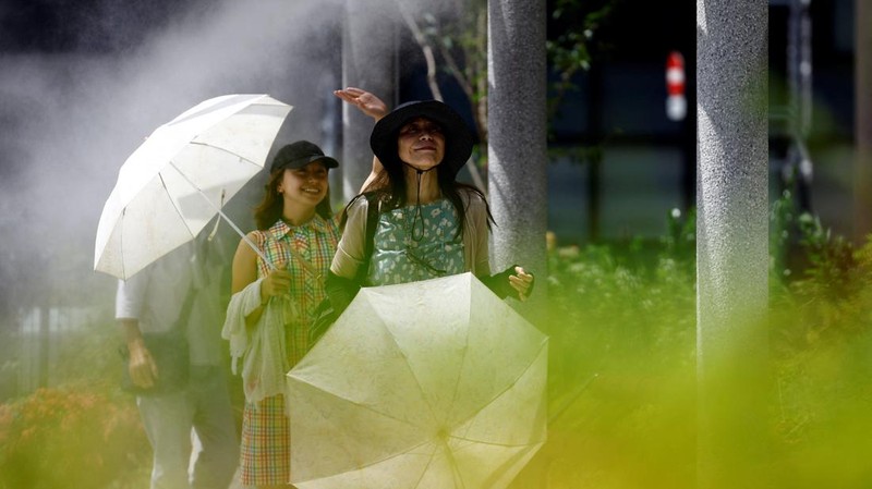 Pengjung saat cuaca panas Taman Kasai Rinkai, Tokyo, Jepang, Selasa (9/7/2024). (AP Photo/Eugene Hoshiko)