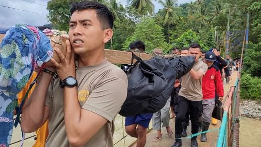 Members of a rescue team carry a victim who died in a landslide at Tulabolo village in Bone Bolango Regency of the Gorontalo Province on July 9, 2024. The death toll from a landslide near an illegal gold mine on Indonesia's central island of Sulawesi had risen to 23 people, while 35 others are still missing, an official said on July 9. (Photo by DIDOT / AFP)