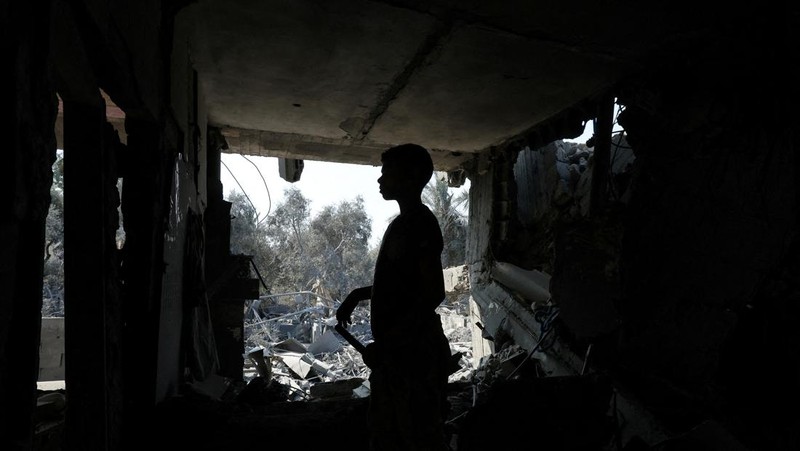 Warga Palestina memeriksa sebuah rumah yang hancur akibat serangan Israel, di tengah konflik Israel-Hamas, di kamp pengungsi Nuseirat, di Jalur Gaza tengah, 9 Juli 2024. (REUTERS/Ramadan Abed)