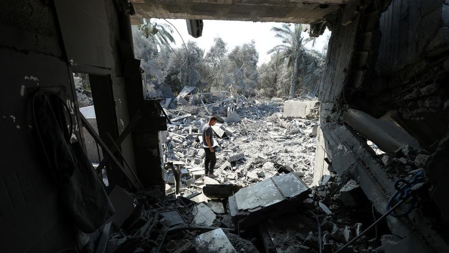 Warga Palestina memeriksa sebuah rumah yang hancur akibat serangan Israel, di tengah konflik Israel-Hamas, di kamp pengungsi Nuseirat, di Jalur Gaza tengah, 9 Juli 2024. (REUTERS/Ramadan Abed)