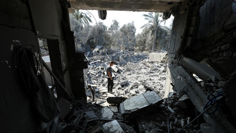Warga Palestina memeriksa sebuah rumah yang hancur akibat serangan Israel, di tengah konflik Israel-Hamas, di kamp pengungsi Nuseirat, di Jalur Gaza tengah, 9 Juli 2024. (REUTERS/Ramadan Abed)