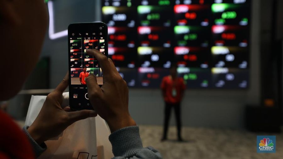 Karyawan berdiri dengan latar belakang layar digital pergerakan Indeks Harga Saham Gabungan (IHSG) di Bursa Efek Indonesia, Jakarta, Kamis (11/7/2024). (²©²ÊÍøÕ¾/Tri Susilo)