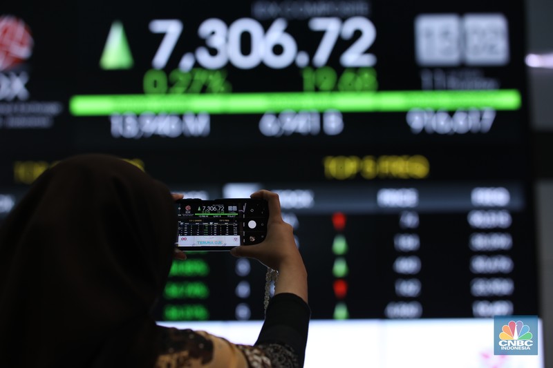 Karyawan berdiri dengan latar belakang layar digital pergerakan Indeks Harga Saham Gabungan (IHSG) di Bursa Efek Indonesia, Jakarta, Kamis (11/7/2024). Karyawan berdiri dengan latar belakang layar digital pergerakan Indeks Harga Saham Gabungan (IHSG) di Bursa Efek Indonesia, Jakarta, Kamis (11/7/2024). (CNBC Indonesia/Tri Susilo)