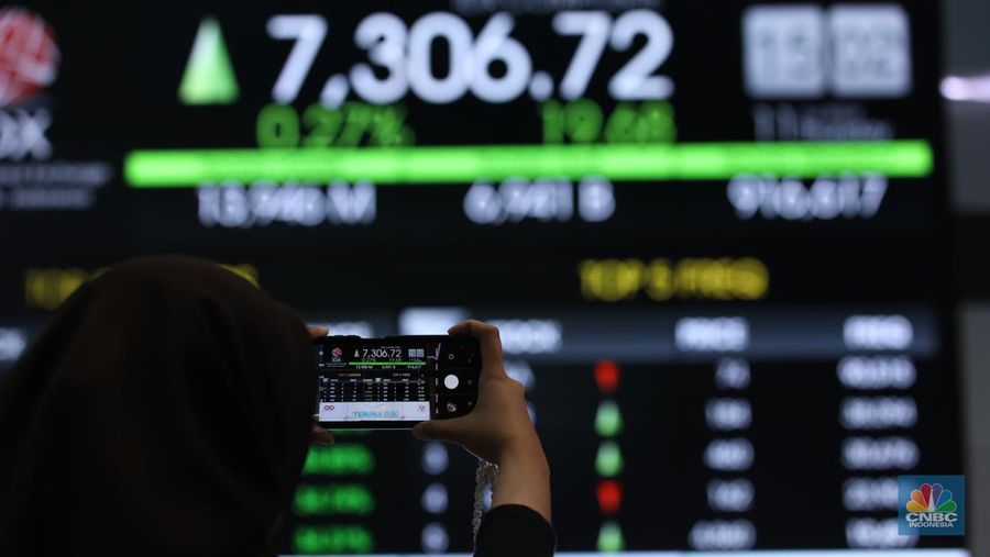Karyawan berdiri dengan latar belakang layar digital pergerakan Indeks Harga Saham Gabungan (IHSG) di Bursa Efek Indonesia, Jakarta, Kamis (11/7/2024). (²©²ÊÍøÕ¾/Tri Susilo)
