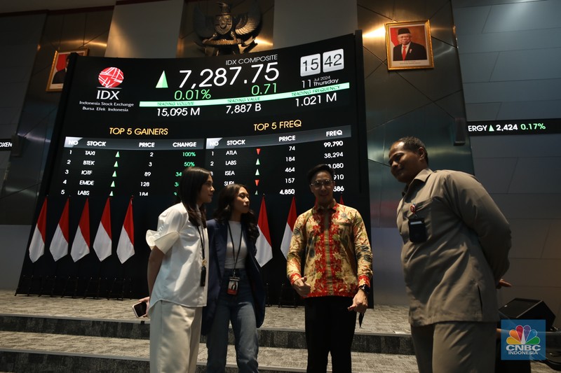 Karyawan berdiri dengan latar belakang layar digital pergerakan Indeks Harga Saham Gabungan (IHSG) di Bursa Efek Indonesia, Jakarta, Kamis (11/7/2024). Karyawan berdiri dengan latar belakang layar digital pergerakan Indeks Harga Saham Gabungan (IHSG) di Bursa Efek Indonesia, Jakarta, Kamis (11/7/2024). (CNBC Indonesia/Tri Susilo)