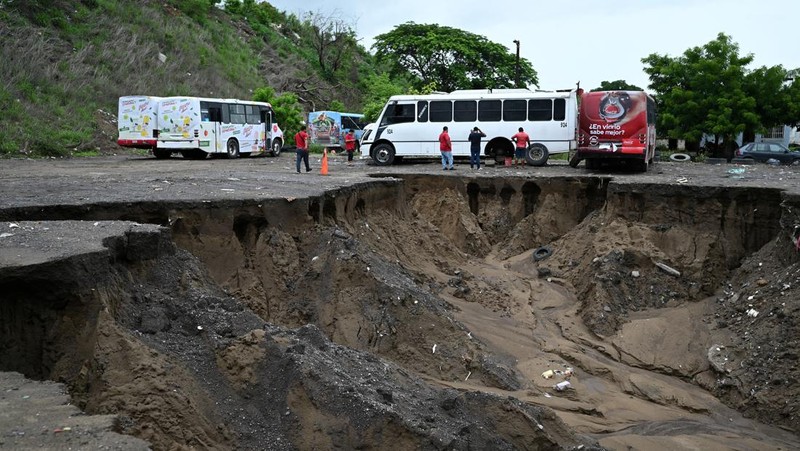 Un automóvil es empujado hacia una carretera inundada durante una fuerte lluvia el 9 de julio de 2024 en Veracruz, México.  (REUTERS/Stringer)