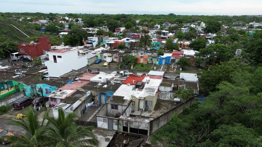 Pria mendorong mobil di jalan yang banjir saat hujan lebat di Veracruz, Meksiko 9 Juli 2024. (REUTERS/Stringer)