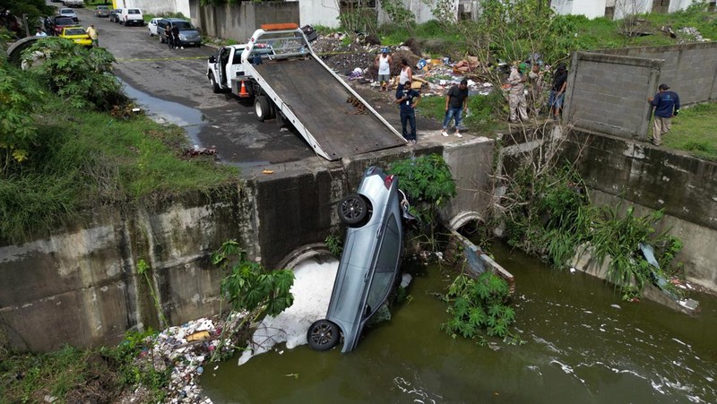 Un automóvil es empujado hacia una carretera inundada durante una fuerte lluvia el 9 de julio de 2024 en Veracruz, México.  (REUTERS/Stringer)