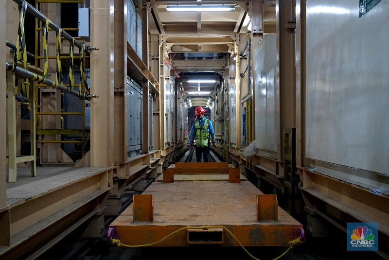 Sejumlah pekerja melintas di samping Tunnel Boring Machine (TBM) atau mesin bor bawah tanah di proyek MRT fase 2A Bundaran HI-Kota di kawasan Glodok, Jakarta, Kamis (11/7/2024). (CNBC Indonesia/Muhammad Sabki)