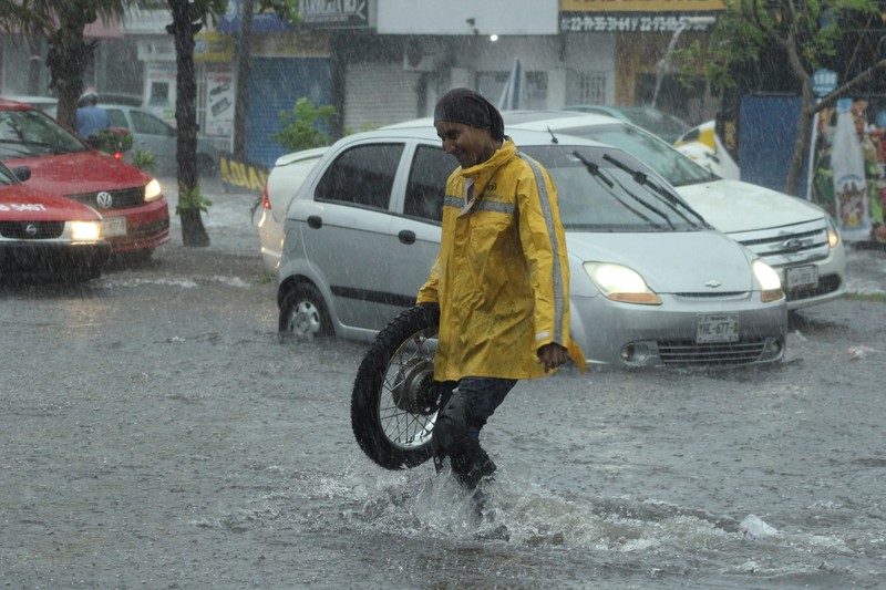 Pria mendorong mobil di jalan yang banjir saat hujan lebat di Veracruz, Meksiko 9 Juli 2024. Pria mendorong mobil di jalan yang banjir saat hujan lebat di Veracruz, Meksiko 9 Juli 2024. (REUTERS/Stringer)