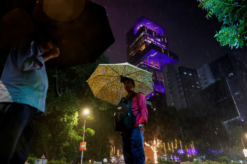 Orang-orang berjalan melewati tempat yang dihiasi lampu menjelang pernikahan putra miliarder Mukesh Ambani, Anant Ambani, dengan Radhika Merchant di Jio World Convention Center di Mumbai, India, Kamis, 11 Juli 2024. Orang-orang berjalan melewati tempat yang dihiasi lampu menjelang pernikahan putra miliarder Mukesh Ambani, Anant Ambani, dengan Radhika Merchant di Jio World Convention Center di Mumbai, India, Kamis, 11 Juli 2024. (AP Photo/Rafiq Maqbool)