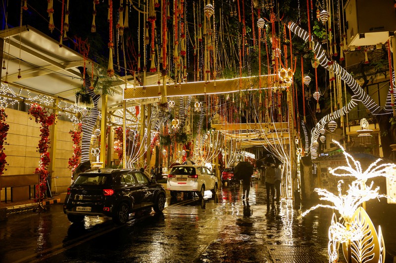 Orang-orang berjalan melewati tempat yang dihiasi lampu menjelang pernikahan putra miliarder Mukesh Ambani, Anant Ambani, dengan Radhika Merchant di Jio World Convention Center di Mumbai, India, Kamis, 11 Juli 2024. Orang-orang berjalan melewati tempat yang dihiasi lampu menjelang pernikahan putra miliarder Mukesh Ambani, Anant Ambani, dengan Radhika Merchant di Jio World Convention Center di Mumbai, India, Kamis, 11 Juli 2024. (AP Photo/Rafiq Maqbool)