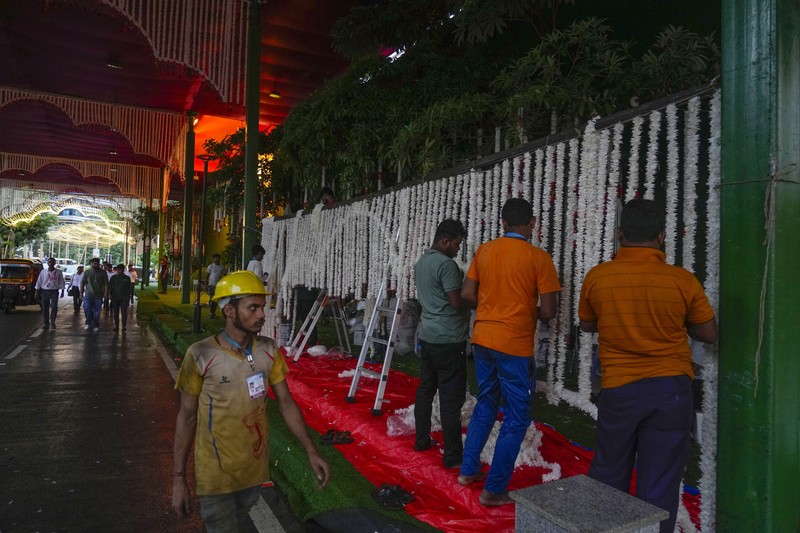 Orang-orang berjalan melewati tempat yang dihiasi lampu menjelang pernikahan putra miliarder Mukesh Ambani, Anant Ambani, dengan Radhika Merchant di Jio World Convention Center di Mumbai, India, Kamis, 11 Juli 2024. Orang-orang berjalan melewati tempat yang dihiasi lampu menjelang pernikahan putra miliarder Mukesh Ambani, Anant Ambani, dengan Radhika Merchant di Jio World Convention Center di Mumbai, India, Kamis, 11 Juli 2024. (AP Photo/Rafiq Maqbool)