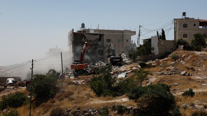 Warga Palesntina menyaksikan penghancuran rumah mereka yang dilakukan oleh militer Israel di Tepi Barat, Kamis (11/7/2024). (REUTERS/Mussa Qawasma)