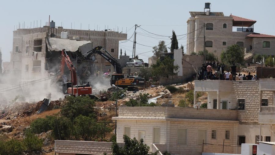 Warga Palesntina menyaksikan penghancuran rumah mereka yang dilakukan oleh militer Israel di Tepi Barat, Kamis (11/7/2024). (REUTERS/Mussa Qawasma)