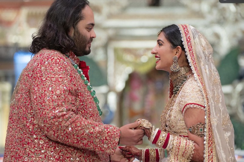 Miliarder Mukesh Ambani, tengah, menggandeng tangan putranya Anant Ambani saat mereka berjalan bersama Nita Ambani, kanan, di pernikahan Anant dan Radhika Merchant di Jio World Convention Center di Mumbai, India, Jumat, 12 Juli 2024. Miliarder Mukesh Ambani, tengah, menggandeng tangan putranya Anant Ambani saat mereka berjalan bersama Nita Ambani, kanan, di pernikahan Anant dan Radhika Merchant di Jio World Convention Center di Mumbai, India, Jumat, 12 Juli 2024. (AP Photo /Rajanish Kakade)