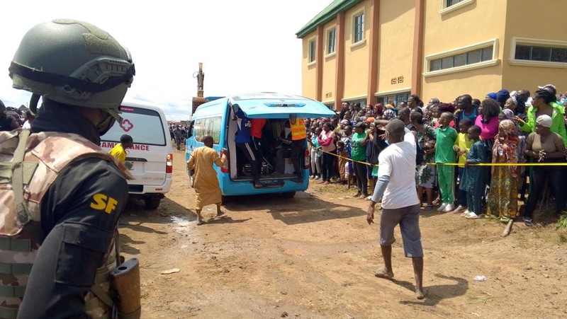 Orang-orang berdiri di dekat reruntuhan gedung sekolah milik Saint Academy yang runtuh di komunitas Busa Buji, negara bagian Plateau, Nigeria 12 Juli 2024. (REUTERS/Joshua Inusa)
