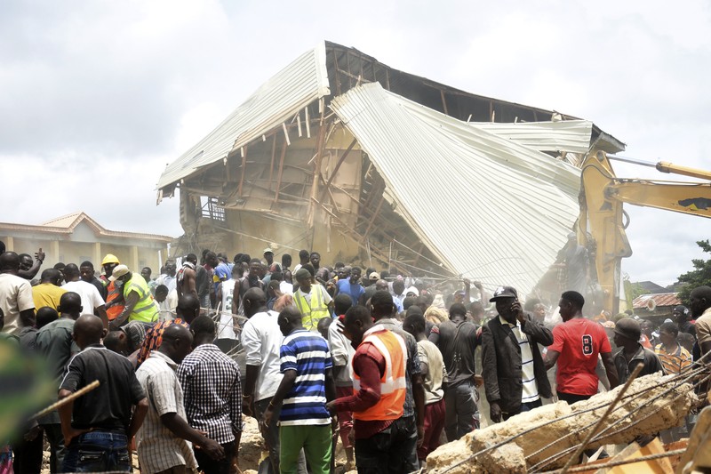 Orang-orang berdiri di dekat reruntuhan gedung sekolah milik Saint Academy yang runtuh di komunitas Busa Buji, negara bagian Plateau, Nigeria 12 Juli 2024. Orang-orang berdiri di dekat reruntuhan gedung sekolah milik Saint Academy yang runtuh di komunitas Busa Buji, negara bagian Plateau, Nigeria 12 Juli 2024. (REUTERS/Joshua Inusa)