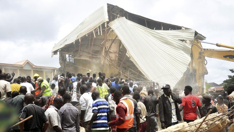 Orang-orang berdiri di dekat reruntuhan gedung sekolah milik Saint Academy yang runtuh di komunitas Busa Buji, negara bagian Plateau, Nigeria 12 Juli 2024. (REUTERS/Joshua Inusa)