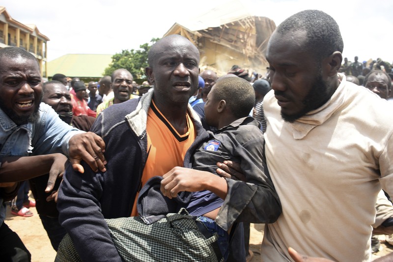 Orang-orang berdiri di dekat reruntuhan gedung sekolah milik Saint Academy yang runtuh di komunitas Busa Buji, negara bagian Plateau, Nigeria 12 Juli 2024. Orang-orang berdiri di dekat reruntuhan gedung sekolah milik Saint Academy yang runtuh di komunitas Busa Buji, negara bagian Plateau, Nigeria 12 Juli 2024. (REUTERS/Joshua Inusa)