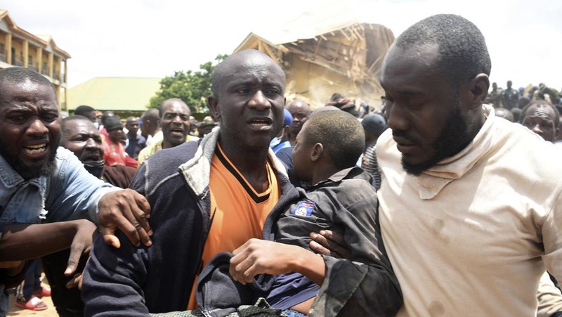 Orang-orang berdiri di dekat reruntuhan gedung sekolah milik Saint Academy yang runtuh di komunitas Busa Buji, negara bagian Plateau, Nigeria 12 Juli 2024. (REUTERS/Joshua Inusa)