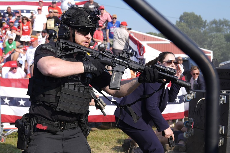 Agen Dinas Rahasia AS mengelilingi panggung saat agen lainnya melindungi calon presiden dari Partai Republik mantan Presiden Donald Trump pada rapat umum kampanye, Sabtu, 13 Juli 2024, di Butler, Pa. (AP/Evan Vucci) Agen Dinas Rahasia AS mengelilingi panggung saat agen lainnya melindungi calon presiden dari Partai Republik mantan Presiden Donald Trump pada rapat umum kampanye, Sabtu, 13 Juli 2024, di Butler, Pa. (AP/Evan Vucci)