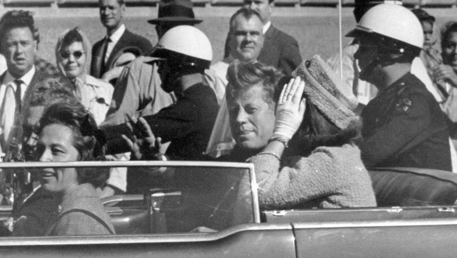 FILE - President John F. Kennedy waves from his car in a motorcade approximately one minute before he was shot, Nov. 22, 1963, in Dallas. Riding with President Kennedy are first lady Jacqueline Kennedy, right, Nellie Connally, second from left, and her husband, Texas Gov. John Connally, far left. (AP Photo/Jim Altgens, File)