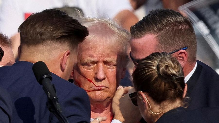 Kandidat presiden dari Partai Republik dan mantan Presiden AS Donald Trump dibantu oleh petugas keamanan setelah terdengar suara tembakan saat kampanye di Butler Farm Show di Butler, Pennsylvania, AS, 13 Juli 2024. (REUTERS/Brendan McDermid)