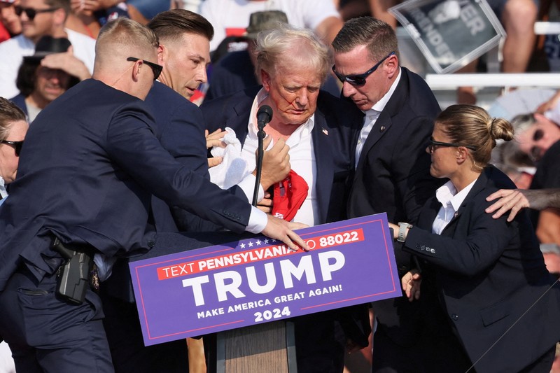 Kandidat presiden dari Partai Republik dan mantan Presiden AS Donald Trump dibantu oleh petugas keamanan setelah terdengar suara tembakan saat kampanye di Butler Farm Show di Butler, Pennsylvania, AS, 13 Juli 2024. Kandidat presiden dari Partai Republik dan mantan Presiden AS Donald Trump dibantu oleh petugas keamanan setelah terdengar suara tembakan saat kampanye di Butler Farm Show di Butler, Pennsylvania, AS, 13 Juli 2024. (REUTERS/Brendan McDermid)