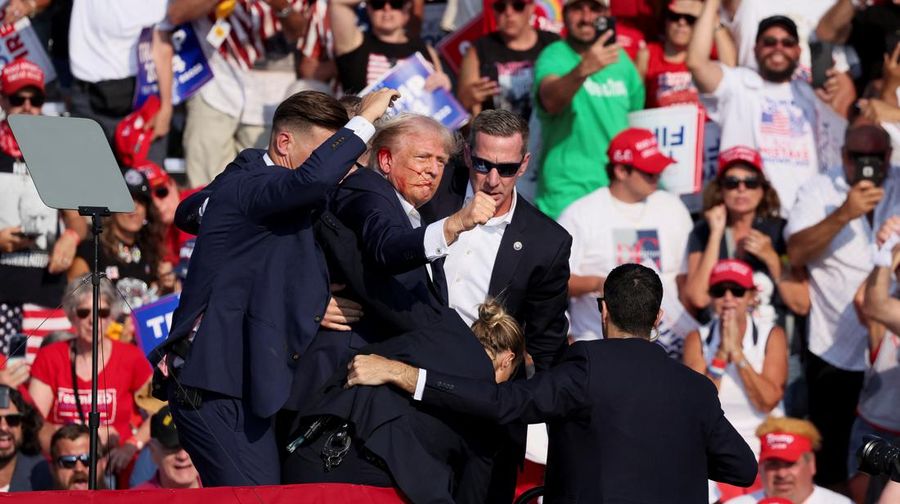Kandidat presiden dari Partai Republik dan mantan Presiden AS Donald Trump dibantu oleh petugas keamanan setelah terdengar suara tembakan saat kampanye di Butler Farm Show di Butler, Pennsylvania, AS, 13 Juli 2024. (REUTERS/Brendan McDermid)