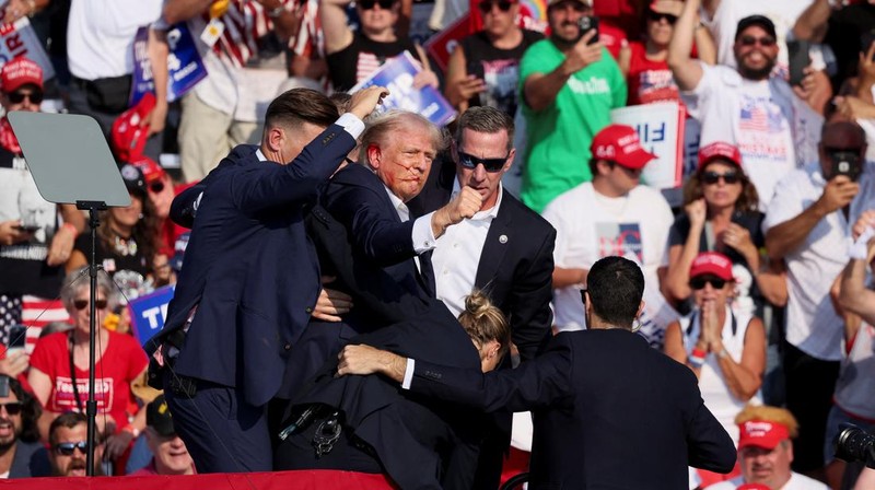Kandidat presiden dari Partai Republik dan mantan Presiden AS Donald Trump dibantu oleh petugas keamanan setelah terdengar suara tembakan saat kampanye di Butler Farm Show di Butler, Pennsylvania, AS, 13 Juli 2024. (REUTERS/Brendan McDermid)