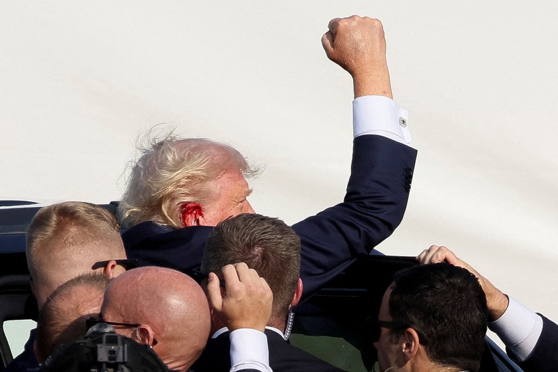 Kandidat presiden dari Partai Republik dan mantan Presiden AS Donald Trump dibantu oleh petugas keamanan setelah terdengar suara tembakan saat kampanye di Butler Farm Show di Butler, Pennsylvania, AS, 13 Juli 2024. (REUTERS/Brendan McDermid)