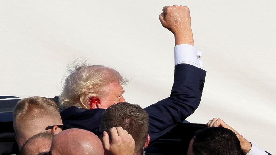 Kandidat presiden dari Partai Republik dan mantan Presiden AS Donald Trump dibantu oleh petugas keamanan setelah terdengar suara tembakan saat kampanye di Butler Farm Show di Butler, Pennsylvania, AS, 13 Juli 2024. (REUTERS/Brendan McDermid)