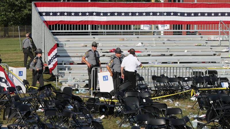 Agen Dinas Rahasia AS mengelilingi panggung saat agen lainnya melindungi calon presiden dari Partai Republik mantan Presiden Donald Trump pada rapat umum kampanye, Sabtu, 13 Juli 2024, di Butler, Pa. (AP/Evan Vucci)