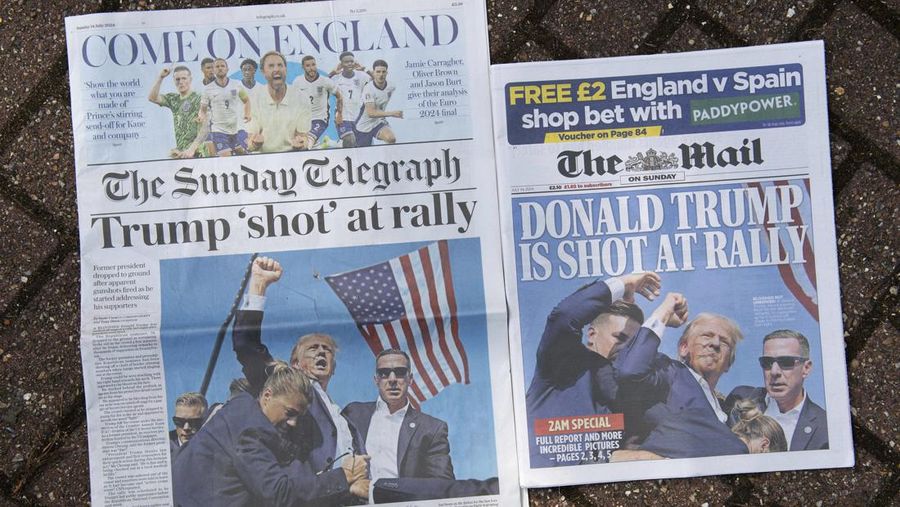 Dua halaman depan surat kabar nasional Inggris, edisi akhir untuk London, Minggu 14 Juli 2024, menampilkan reaksi terhadap peristiwa bekas kampanye Presiden Trump di Butler, Pennsylvania. (AP Photo/Thomas Krych)