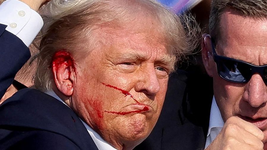 Republican presidential candidate and former U.S. President Donald Trump gestures as he is assisted by the Secret Service after gunfire rang out during a campaign rally at the Butler Farm Show in Butler, Pennsylvania, U.S., July 13, 2024. REUTERS/Brendan McDermid