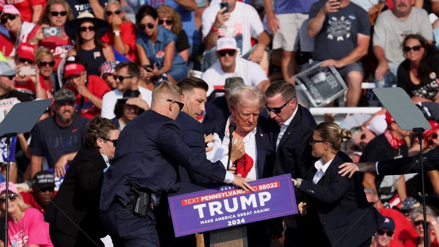 Republican presidential candidate and former U.S. President Donald Trump is assisted by U.S. Secret Service personnel after gunfire rang out during a campaign rally at the Butler Farm Show in Butler, Pennsylvania, U.S., July 13, 2024. REUTERS/Brendan McDermid     TPX IMAGES OF THE DAY