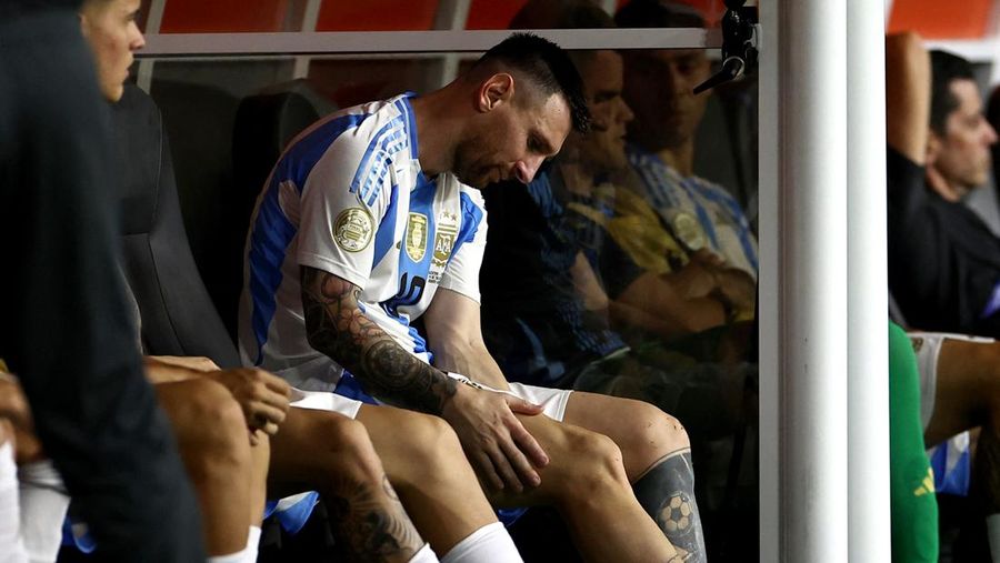 Pemain Argentina Lionel Messi duduk di bangku cadangan setelah meninggalkan lapangan karena cedera saat pertandingan sepak bola final Copa America melawan Kolombia di Miami Gardens, Fl., Minggu, 14 Juli 2024. (AP Photo/Julio Cortez)