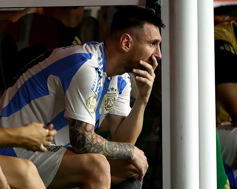 Pemain Argentina Lionel Messi duduk di bangku cadangan setelah meninggalkan lapangan karena cedera saat pertandingan sepak bola final Copa America melawan Kolombia di Miami Gardens, Fl., Minggu, 14 Juli 2024. (AP Photo/Julio Cortez)