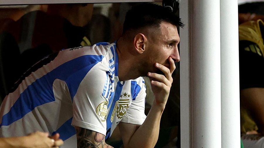 Pemain Argentina Lionel Messi duduk di bangku cadangan setelah meninggalkan lapangan karena cedera saat pertandingan sepak bola final Copa America melawan Kolombia di Miami Gardens, Fl., Minggu, 14 Juli 2024. (AP Photo/Julio Cortez)