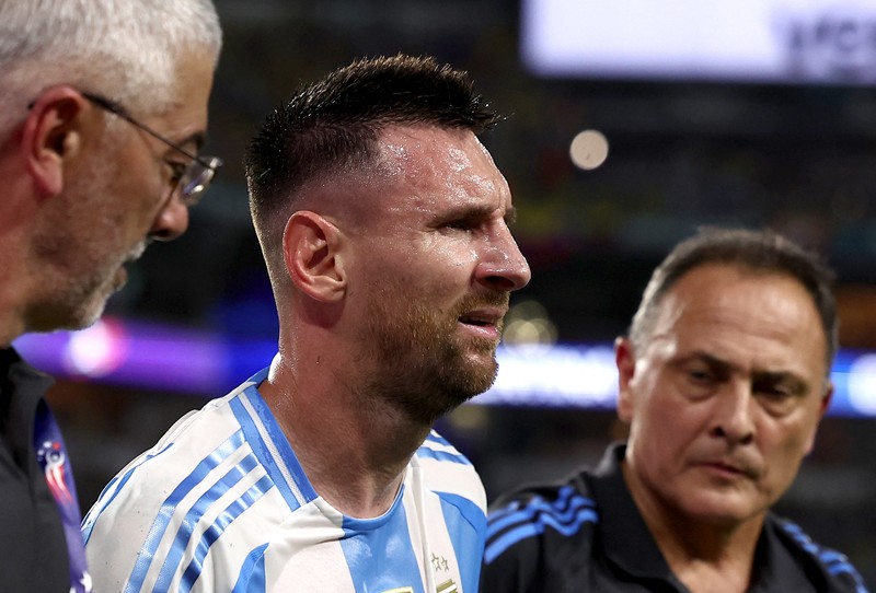 Pemain Argentina Lionel Messi duduk di bangku cadangan setelah meninggalkan lapangan karena cedera saat pertandingan sepak bola final Copa America melawan Kolombia di Miami Gardens, Fl., Minggu, 14 Juli 2024. (AP Photo/Julio Cortez)