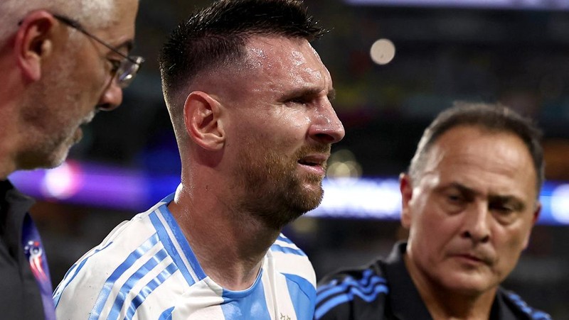 Pemain Argentina Lionel Messi duduk di bangku cadangan setelah meninggalkan lapangan karena cedera saat pertandingan sepak bola final Copa America melawan Kolombia di Miami Gardens, Fl., Minggu, 14 Juli 2024. (AP Photo/Julio Cortez)