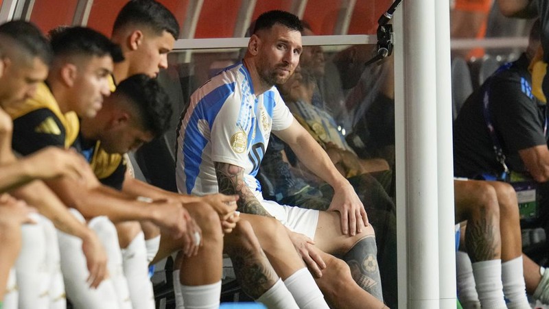 Pemain Argentina Lionel Messi duduk di bangku cadangan setelah meninggalkan lapangan karena cedera saat pertandingan sepak bola final Copa America melawan Kolombia di Miami Gardens, Fl., Minggu, 14 Juli 2024. (AP Photo/Julio Cortez)