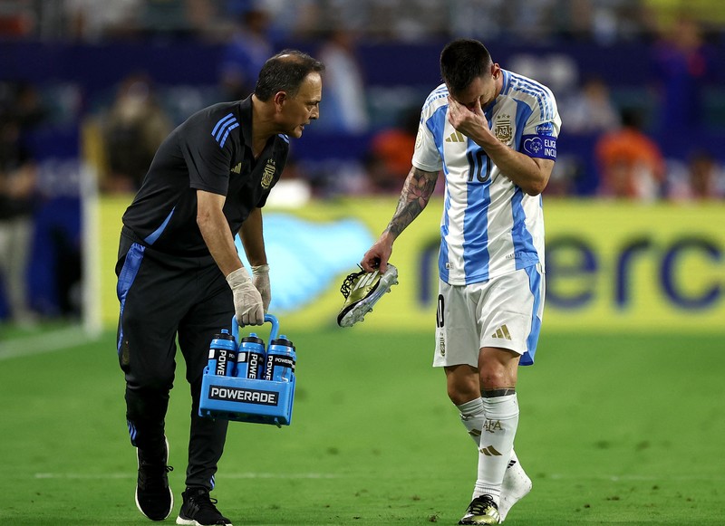 Pemain Argentina Lionel Messi duduk di bangku cadangan setelah meninggalkan lapangan karena cedera saat pertandingan sepak bola final Copa America melawan Kolombia di Miami Gardens, Fl., Minggu, 14 Juli 2024. (AP Photo/Julio Cortez)